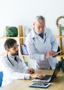 Young doctor showing data to senior colleague